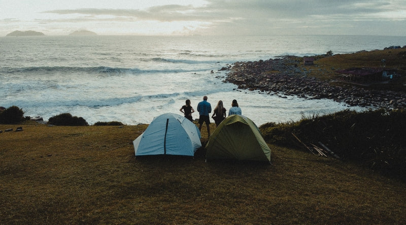 Tentes 3 places installées sur une colline face à l'océan - 4 personnes regardent l'horizon