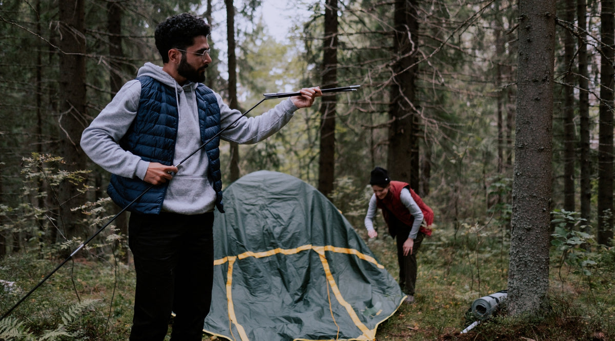 Couple en forêt qui installe une tente 2 places autoportante - Tente autoportée verte pour deux personnes