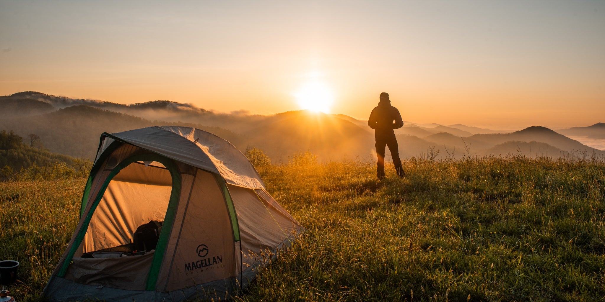 Tente 1 place au sommet d'une montagne avec un campeur regardant le coucher de soleil