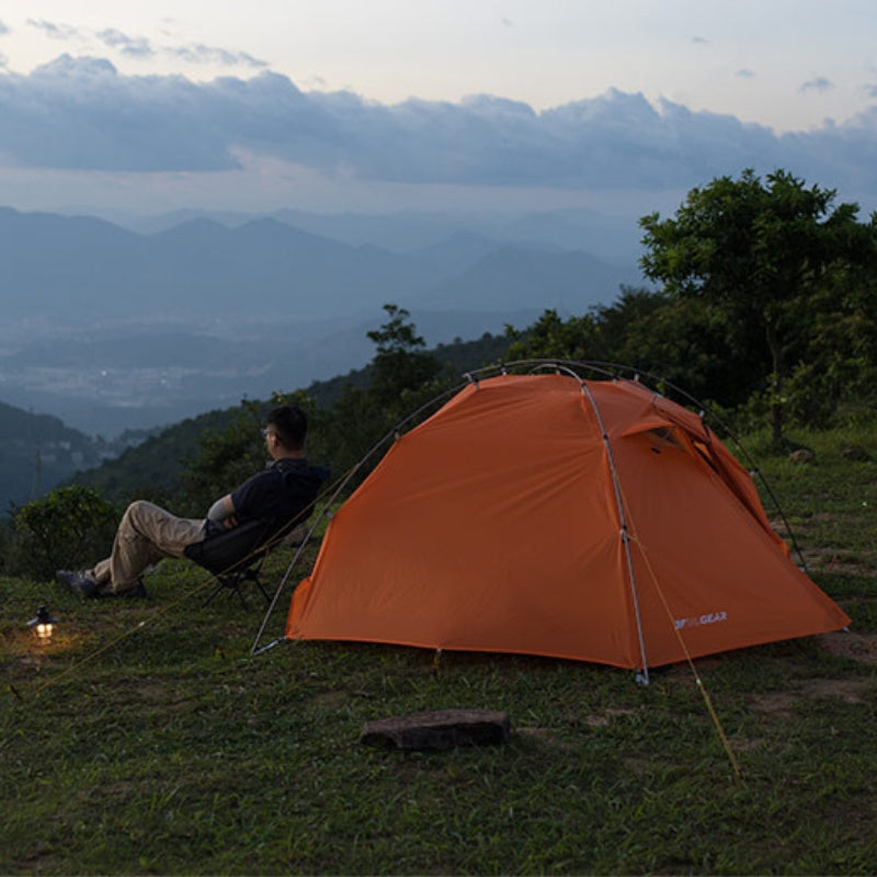 Jeune homme assis devant la tente 2 places Taiji 2 de 3F UL